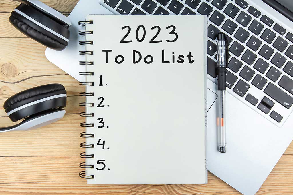 En blokk på en bærbar data, ved siden av ligger en pen og et headset, på blokka står det 2023 to do list og punkter med tall.
